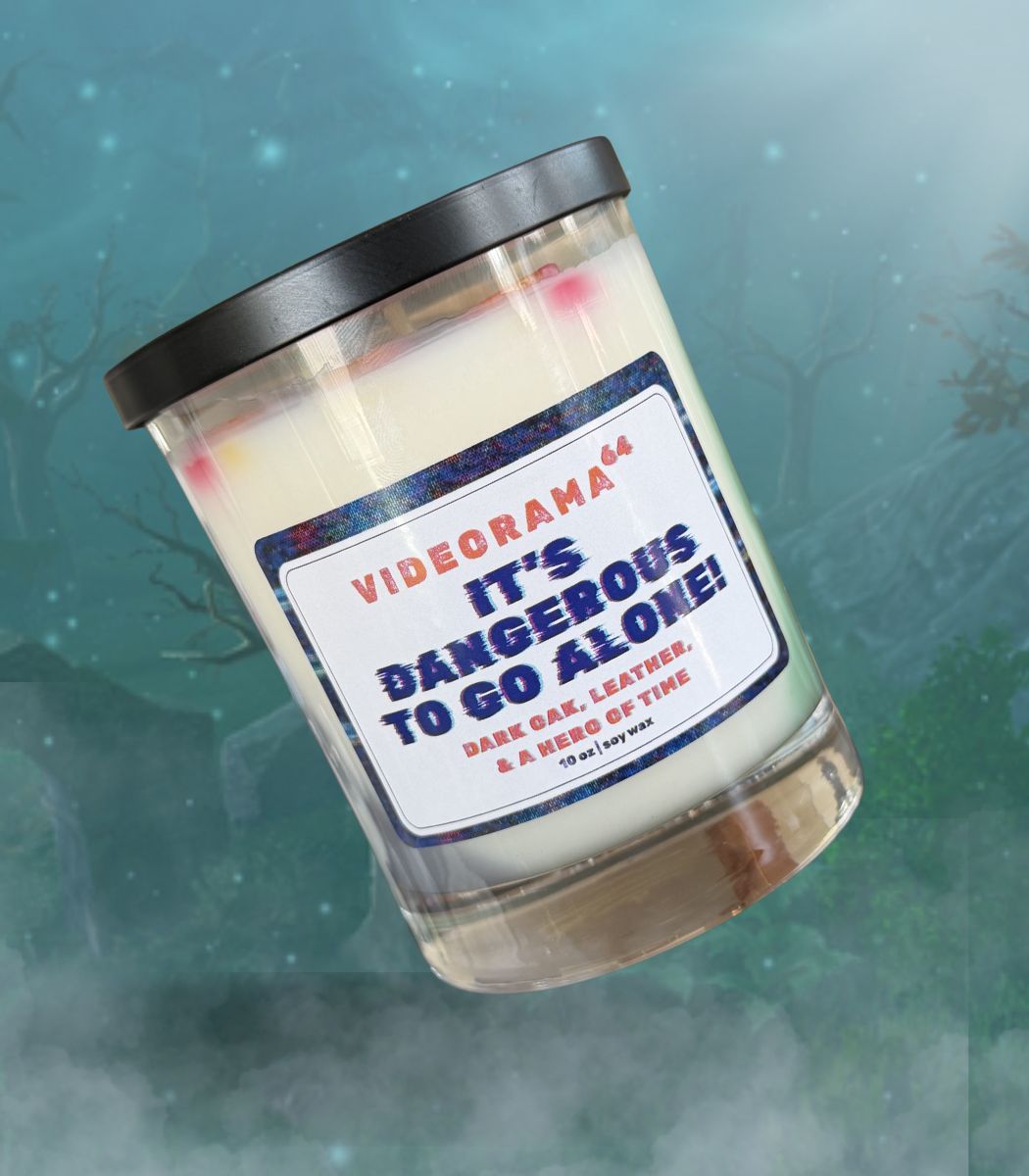 Videorama64 "It's Dangerous to Go Alone" Zelda-inspired soy candle, 10 oz, dark oak and leather scent, glitch-style label, misty forest background